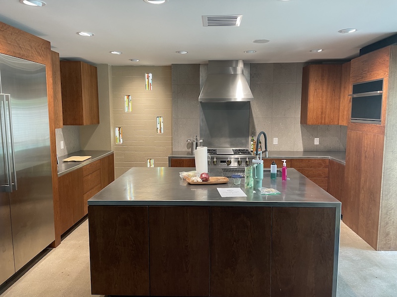 Picture of a kitchen with custom cherry cabinetry and stainless steel countertop.