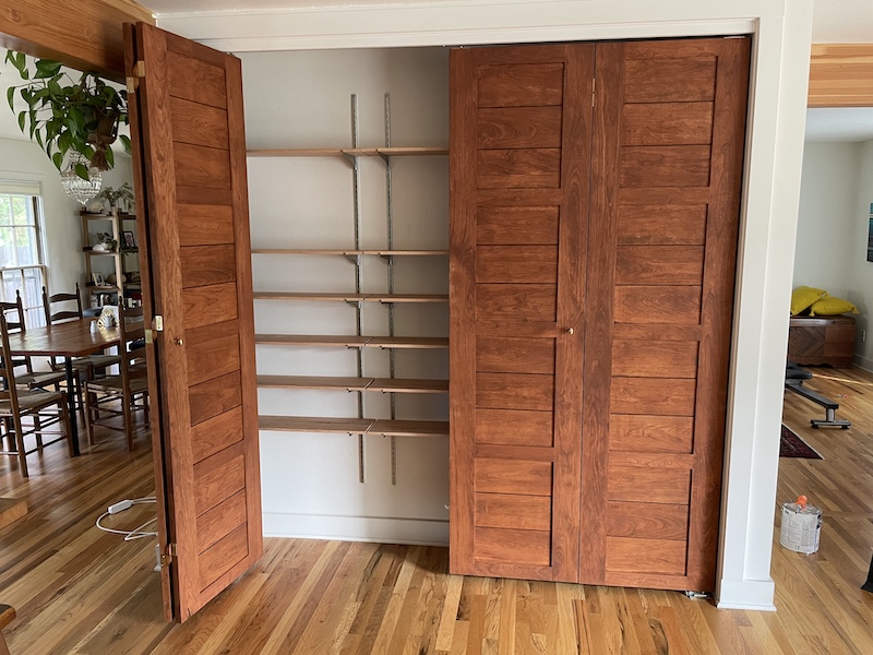 Picture of a closet with one bi-fold door ajar to show interior shelving.