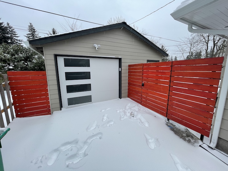 Horizontal slatted fence with electronic lock gate.